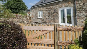 Une maison en pierre avec un portail en bois, une fenêtre et une porte.