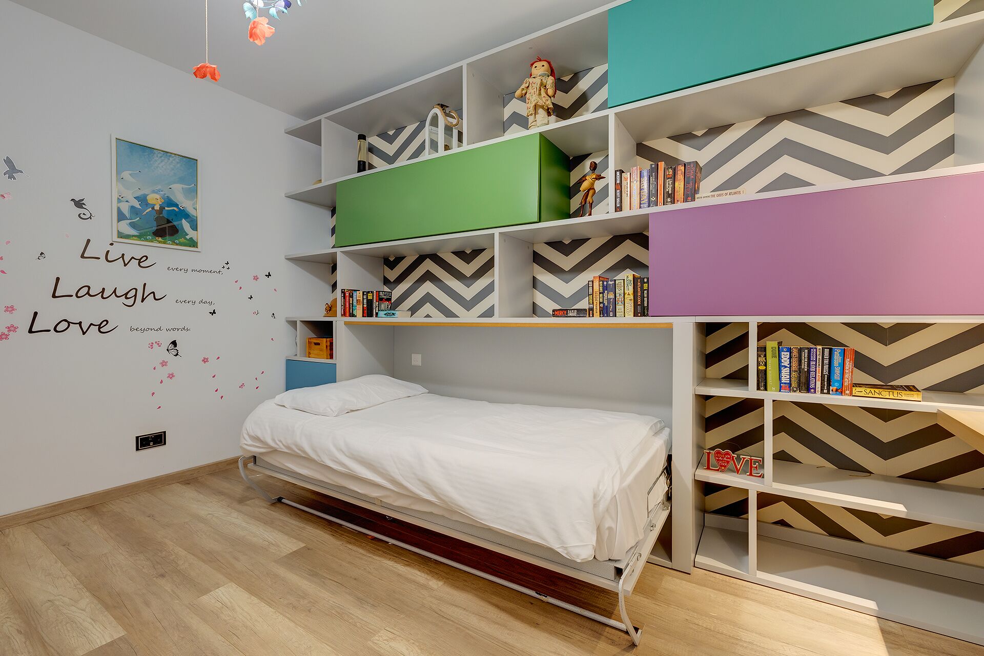 Un dormitorio con una cama, una estantería y una pared decorada con mensajes motivacionales.
