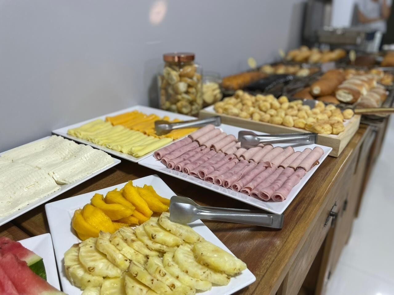 Un buffet con diversi cibi, tra cui frutta, pasticceria e carni.