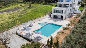 A modern two-story house with a swimming pool, outdoor seating, and a view of the surrounding landscape. - Destino villa ,huge pool,Near Rethymno (Agios Markos)