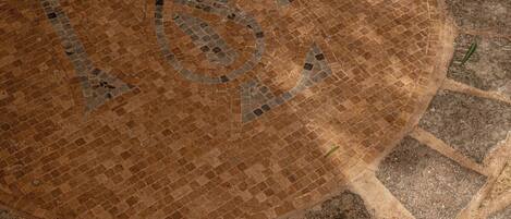 A circular mosaic tile with a pattern of interlocking shapes.
