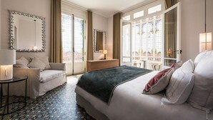 Een hotelkamer met een bed, een slaapbank, een dressoir en een spiegel.