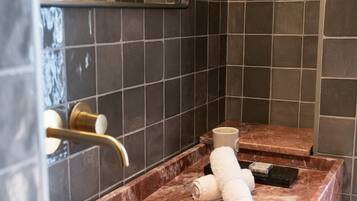 Une salle de bain avec un lavabo en marbre, un porte-serviettes et un miroir.