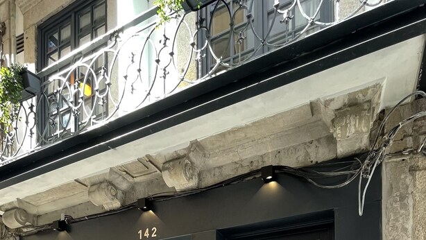A building facade with numbered doors, a 'Check-In' sign, and a 'myStay' sign indicating a hotel or lodging service. - MyStay Porto São Bento (Porto)