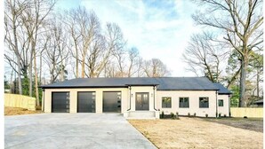 A two-story house with a garage, a front porch, and a driveway. - Entire Home- Immaculate 5 bedrooms Sleeps 13 (Memphis)