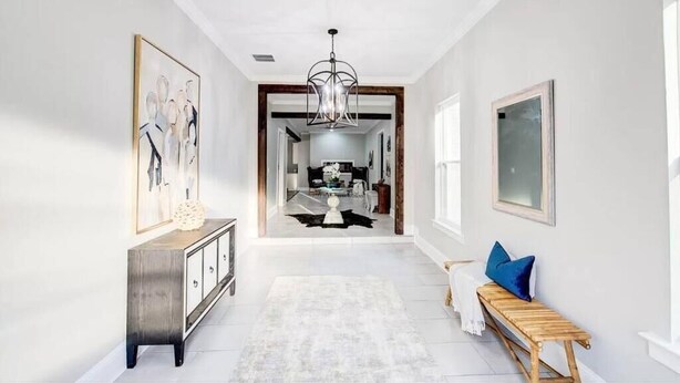 A hallway with a wooden bench, a white rug, and a chandelier. - Entire Home- Immaculate 5 bedrooms Sleeps 13 (Memphis)