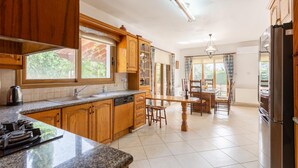Una cocina con armarios de madera, encimera de granito, lavavajillas integrado y un ventanal grande.