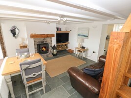 A cozy living room with a fireplace, a dining area, and a comfortable seating area.