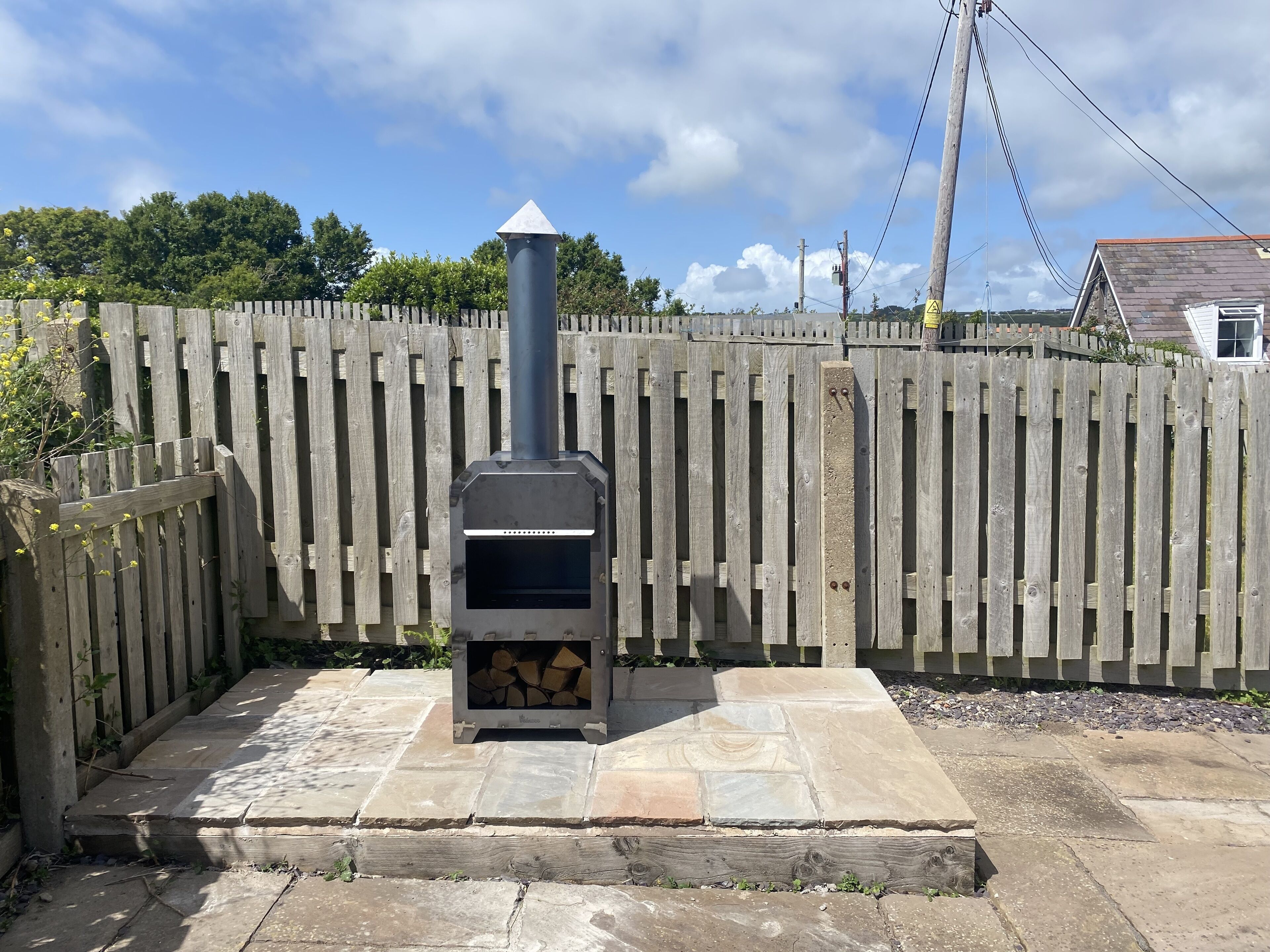 A stone patio with a wood-burning stove.