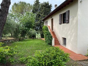 Un bâtiment blanc avec un escalier à degrés recouverts de tuiles rouges et un mur en pierre.