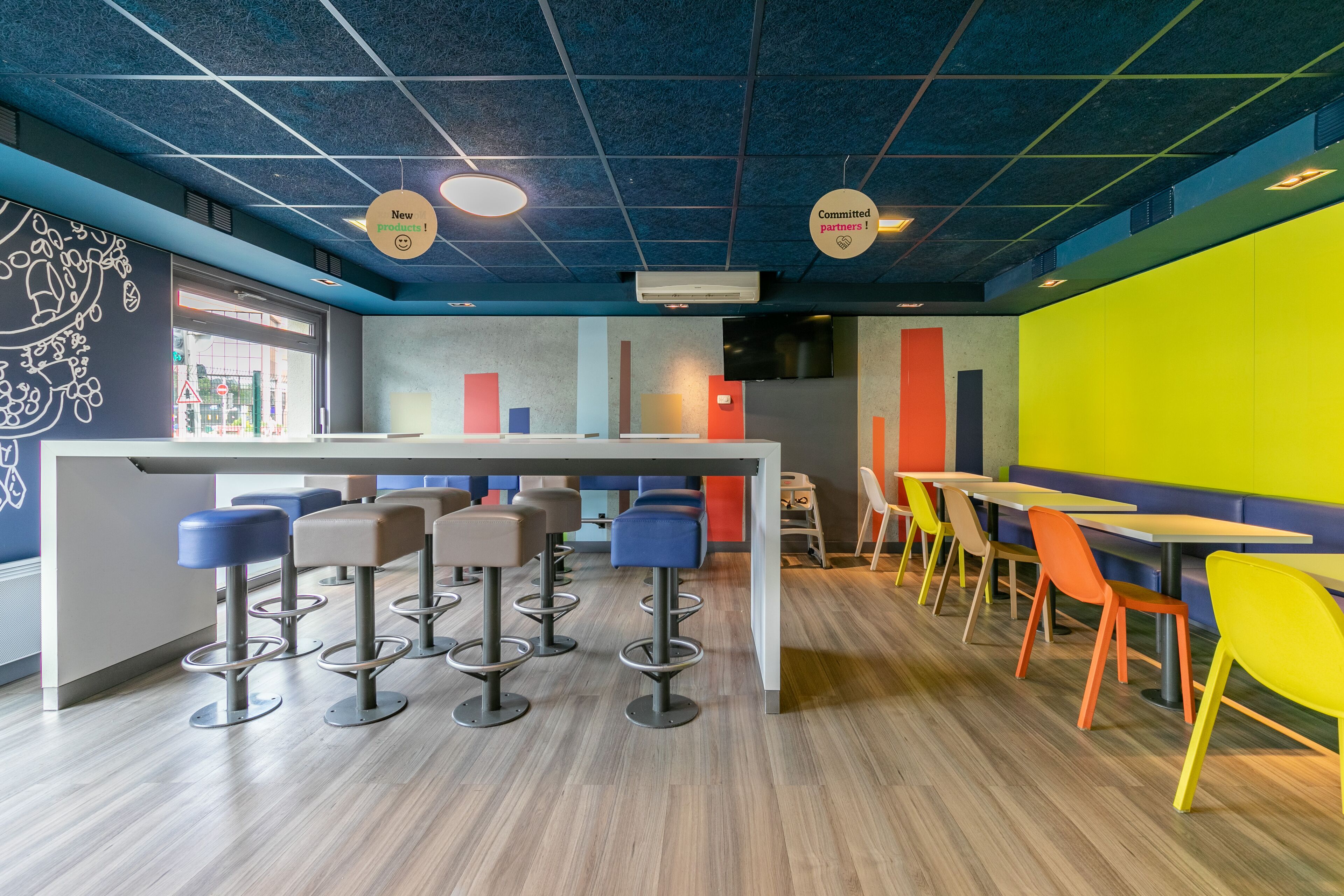 Zona de bar moderna con taburetes, mesas y una barra.