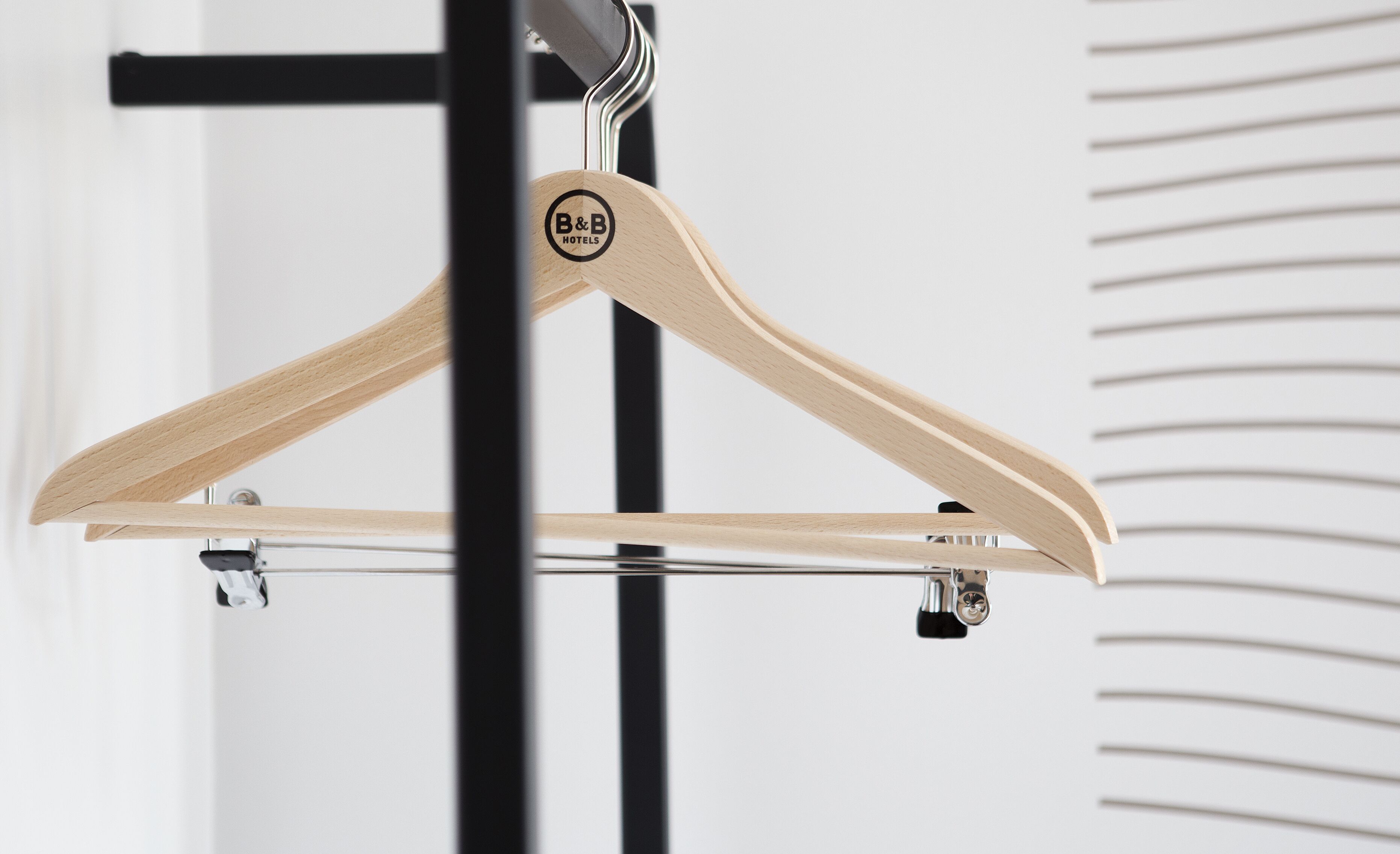 A wooden hanger with a logo on a metal stand.