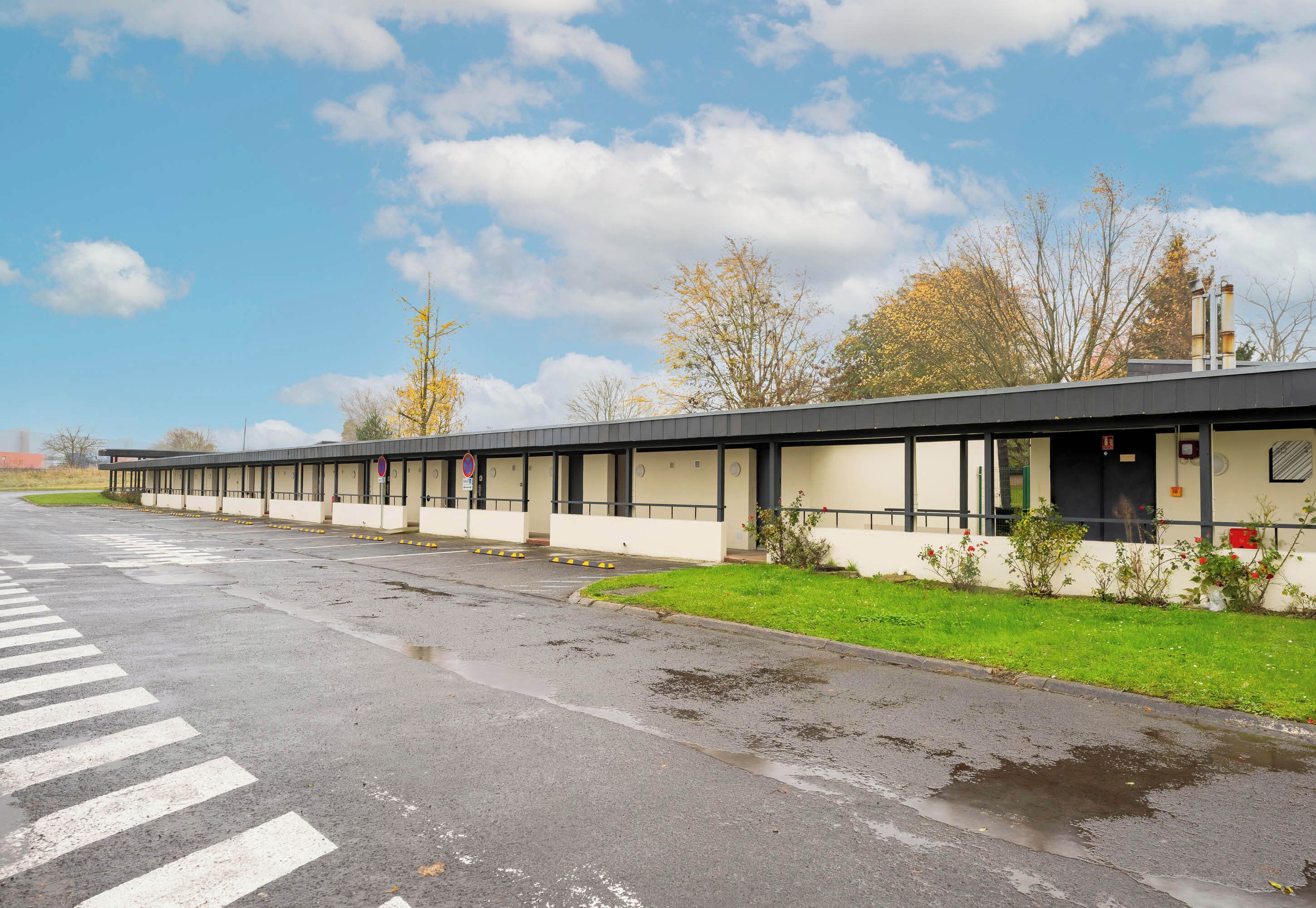 A modern building with a flat roof and a series of windows.