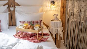 Une chambre confortable avec une tête de lit en bois, une table de chevet avec une lampe et un plateau contenant des éléments pour le petit-déjeuner.