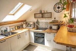 A modern kitchen with a skylight, wooden countertops, white cabinets, and a built-in oven. - Charming romantic 4-star loft with private garage (Barr)