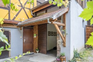 A traditional building with a wooden door, a small porch, and a potted plant.