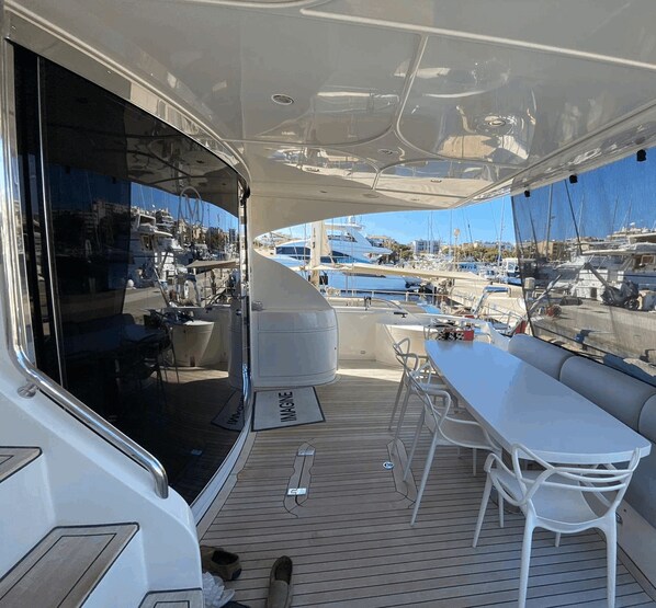 Una amplia terraza con comedor, bar y zona de estar con vista al puerto deportivo.