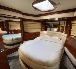 Un dormitorio lujoso con una cama grande, armarios de madera y un tragaluz.