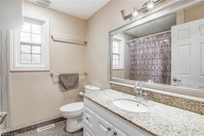 Een bad/douchecombinatie, toiletpapier