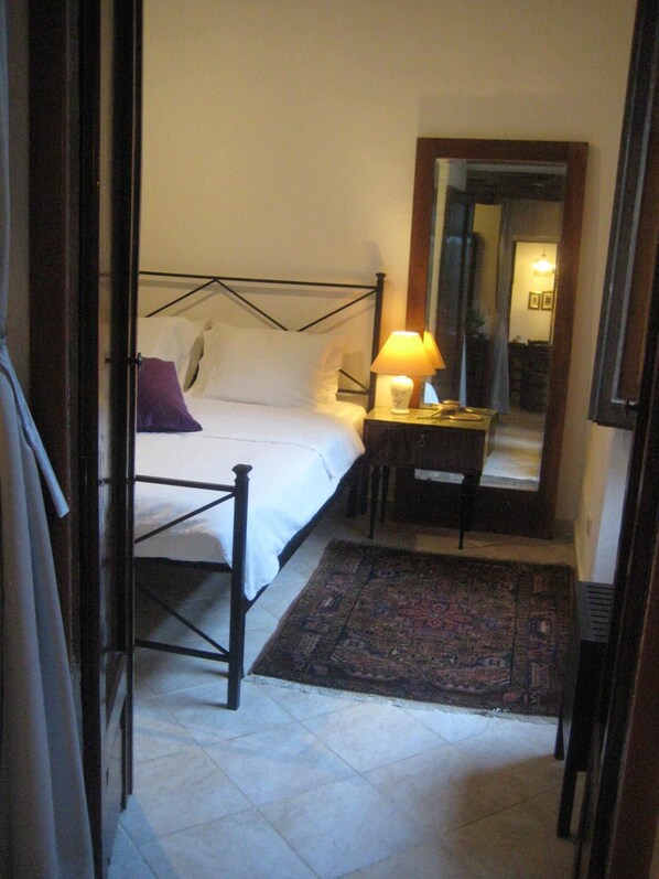 Ein Schlafzimmer mit Bett, Nachttisch, Lampe und Teppich.