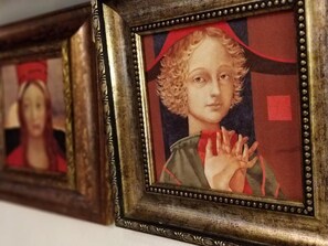 Une série d’œuvres d’art encadrées, dotées de cadres métalliques richement décorés et présentant un thème chromatique uniforme, axé sur les couleurs rouge et or.