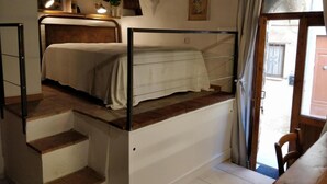 A compact room with a bunk bed, a small desk, and a chair. There is a staircase leading to an upper level. - Casa Messi - Casa Messi a Vicolo Della Rivolta 25 Apt 5 (Pitigliano)