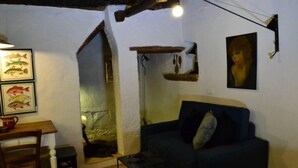Un salon chaleureux avec un canapé, une petite table et une décoration murale sur le thème des poissons.
