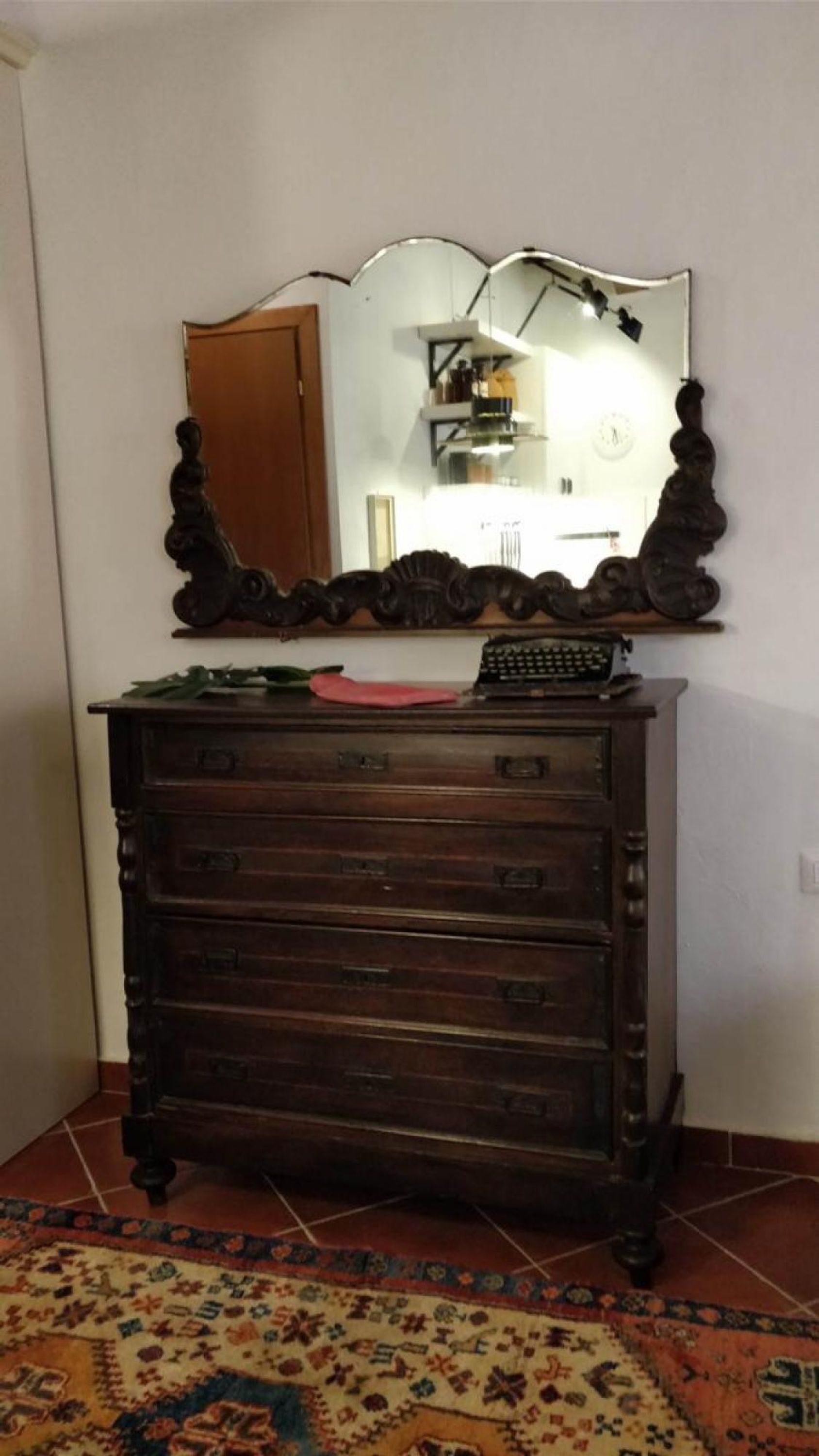 A wooden dresser with multiple drawers and a mirror above it.