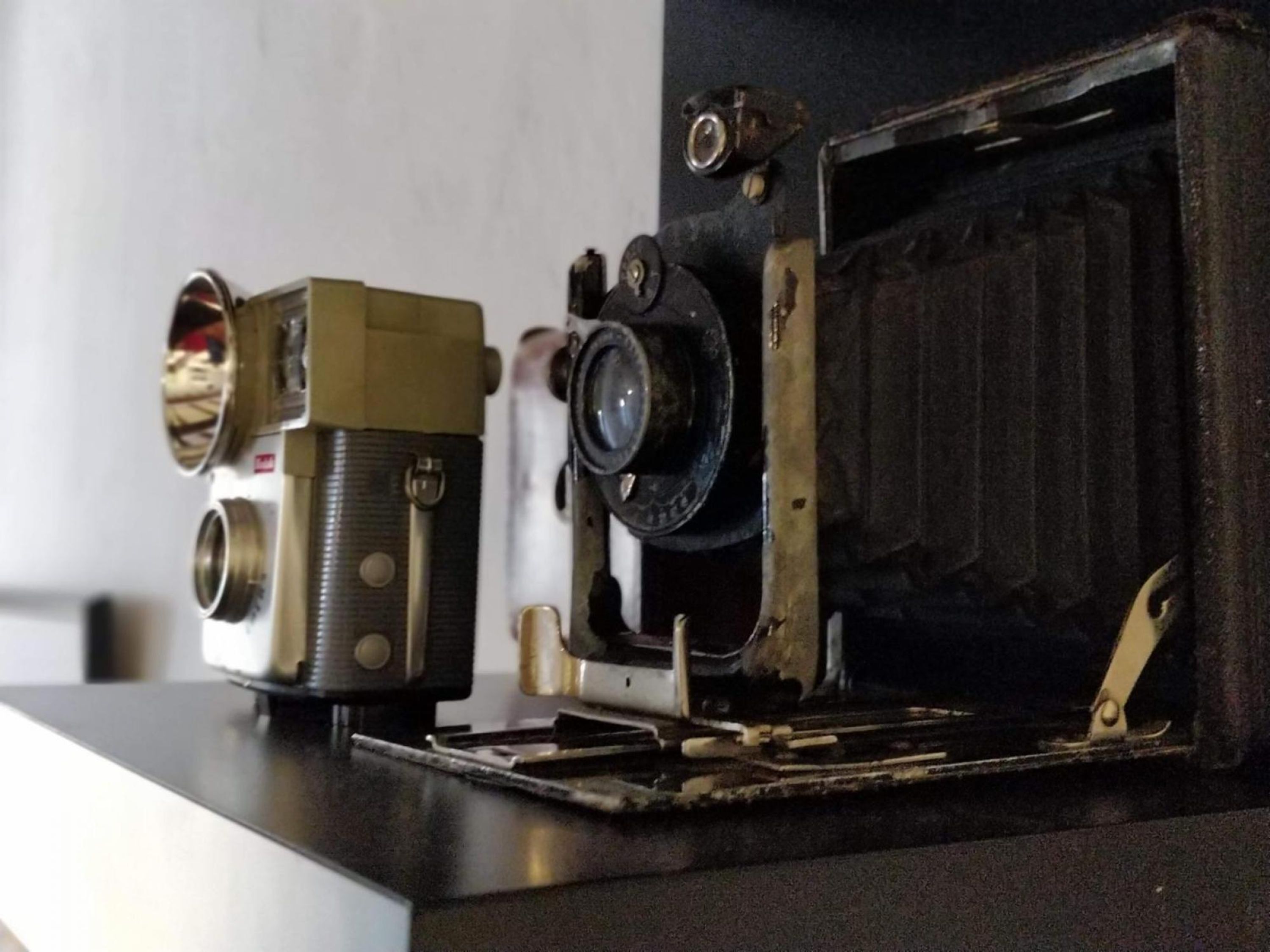 Zwei alte Fotoapparate auf einem Tisch.