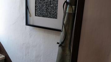 Una obra de arte en un marco en la pared, una silla de metal y una escalera.