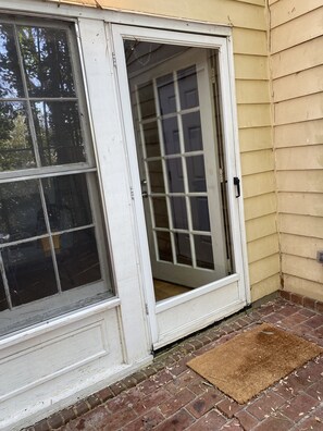 A white door with a glass panel, a brown doormat, and a brick floor. - Lovely condo centrally located in Winston-Salem (Winston-Salem)