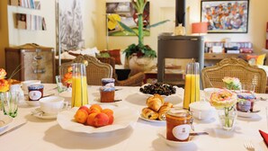 Uma mesa de café da manhã com frutas, doces e bebidas.