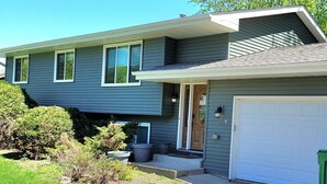 A modern two-story house with a garage, a front porch, and a well-maintained lawn. - Clean, Comfy, digs close to all the attractions (Eagan)