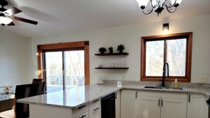 A modern kitchen with white cabinets, a granite countertop, a black faucet, and a window above the sink. - Clean, Comfy, digs close to all the attractions (Eagan)