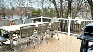 A wooden deck with a table and chairs, a grill, and a white railing. - Clean, Comfy, digs close to all the attractions (Eagan)