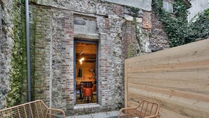 Un bâtiment rustique en briques, doté d’une porte en bois qui donne sur une salle à manger.