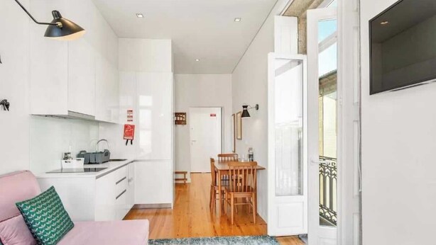 A compact living space with a kitchenette, a dining area, and a balcony.