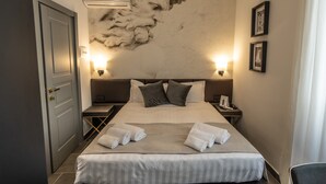 A hotel room with a bed, a nightstand, a wall-mounted phone, and a wall-mounted air conditioner. - Relais Manzoni (Rome)