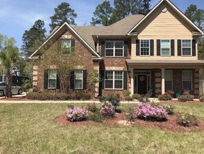 Stunning two-story home with a brick and siding facade, featuring a gable roof and a charming covered entryway.