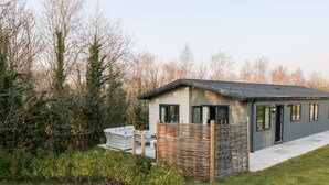 A modern house with a small porch, a fenced garden, and a pathway leading to the entrance. - Mayflower (Lifton)