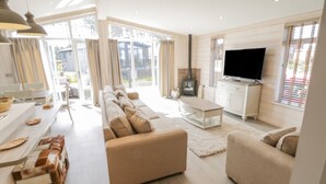 A modern living room with a sofa, a coffee table, a TV, and a fireplace.