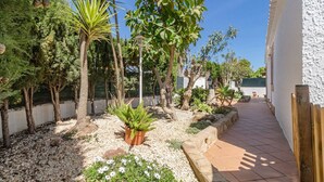 A garden with various plants and a paved walkway. - VILLA MICA  Cheerful 3 bedroom villa with pool and A/C (Son Carrió)