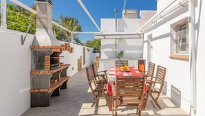 A patio with a grill, table, and chairs. - VILLA MICA  Cheerful 3 bedroom villa with pool and A/C (Son Carrió)