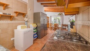 A compact kitchen with a built-in washing machine, a refrigerator, and a gas stove. - VILLA MICA  Cheerful 3 bedroom villa with pool and A/C (Son Carrió)