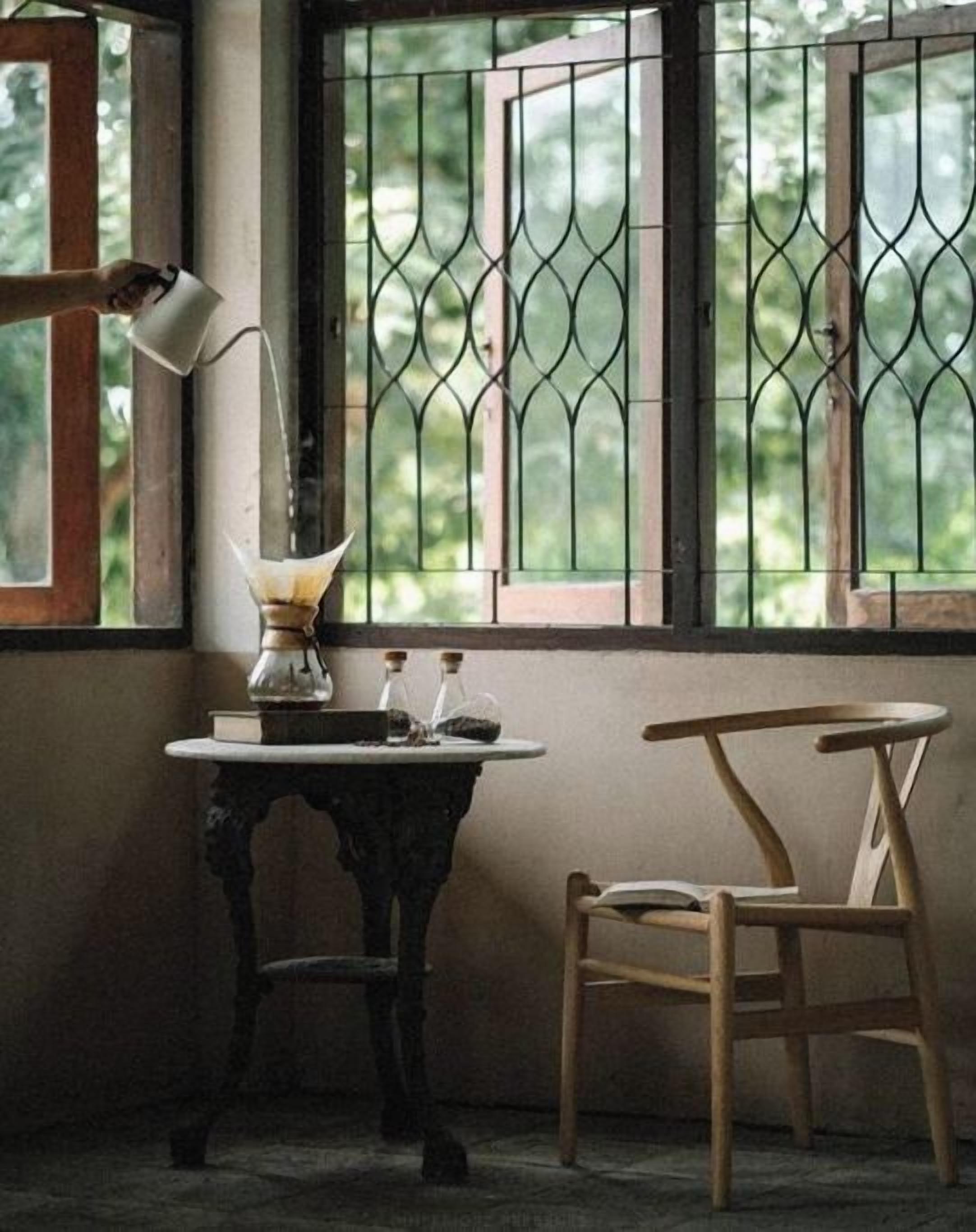 Una habitación de esquina con una mesa, una silla y una ventana con rejas.