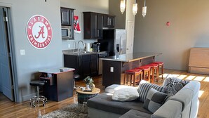 Een moderne woonkamer met een modulaire bank, een salontafel en een keuken op de achtergrond.