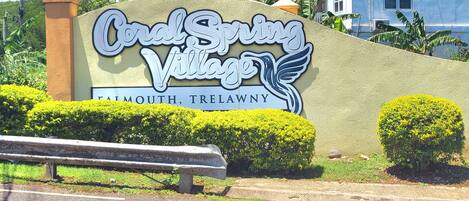 Schild für Coral Springs Village in Tatham, Trelawny.