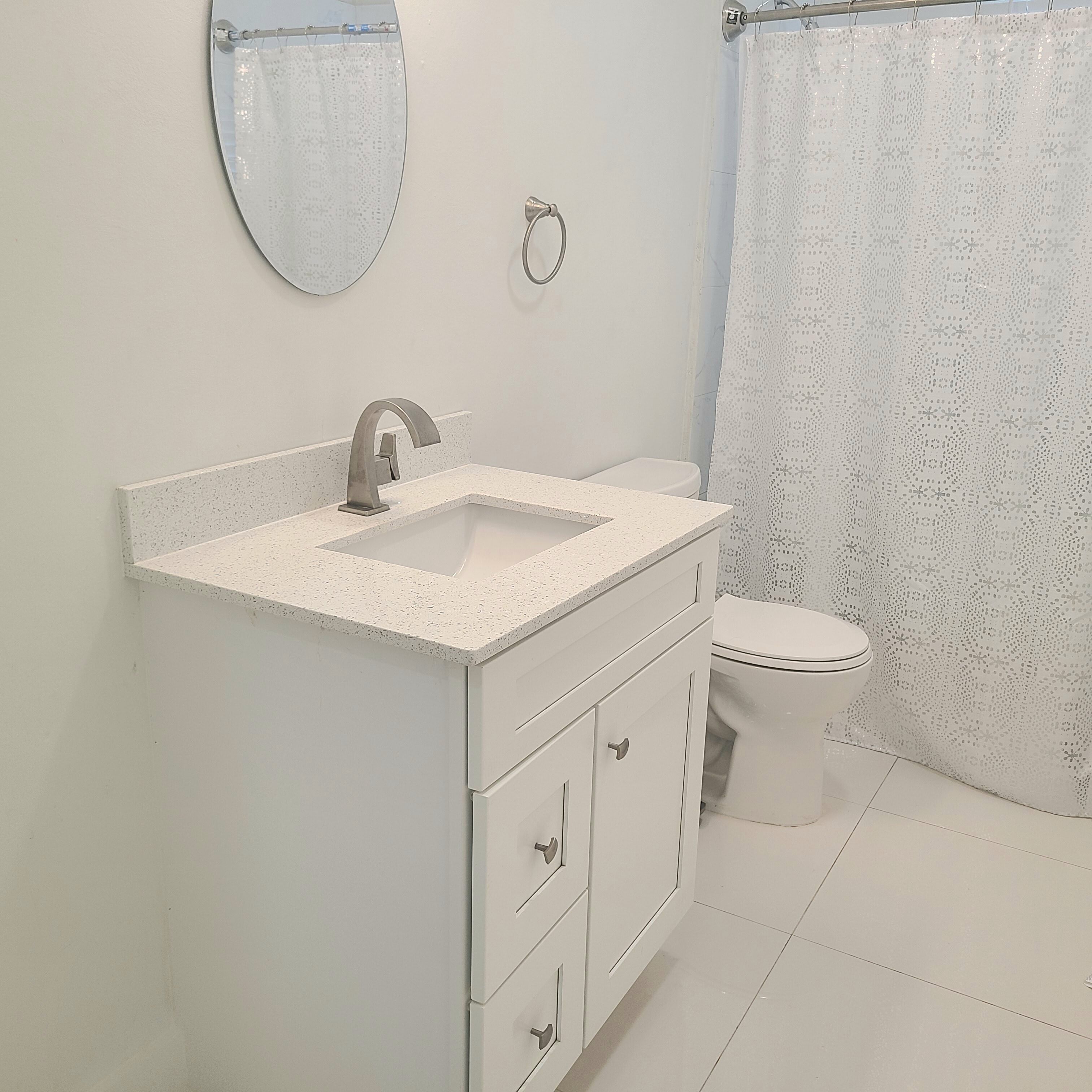 A bathroom with a white sink, mirror, and toilet.