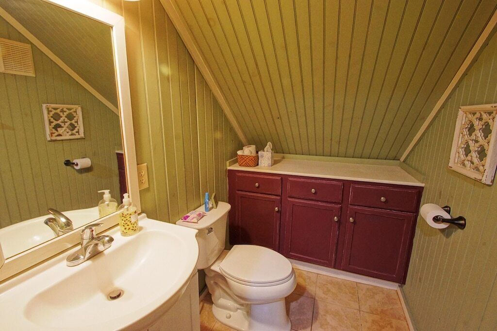 Une salle de bain avec un lavabo blanc, des toilettes et un meuble-lavabo avec un miroir.