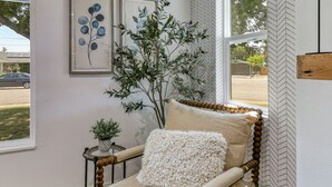 A room with a wooden chair, a small table with a plant, and two framed artworks on the wall. - ***Carpenter Lane*** (Redding)